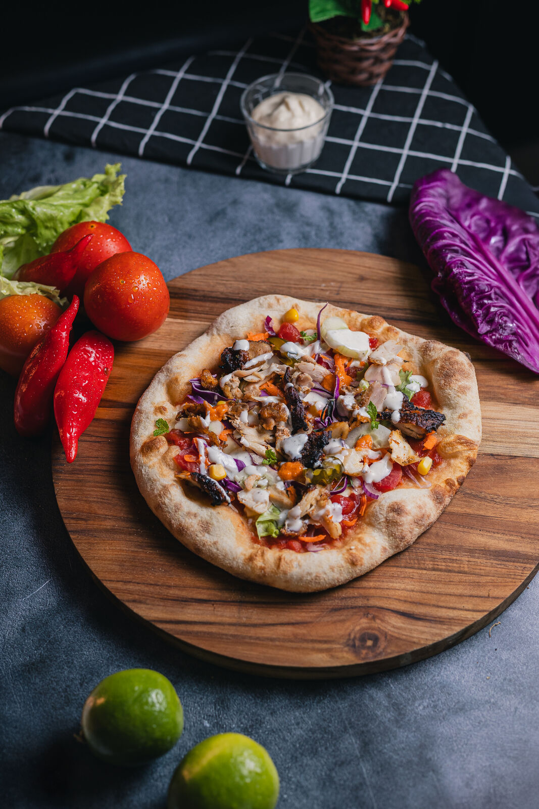 Pizza de kebab artesanal da Fabulous Kebab com carne fatiada e vegetais, sobre tábua de madeira e fundo escuro